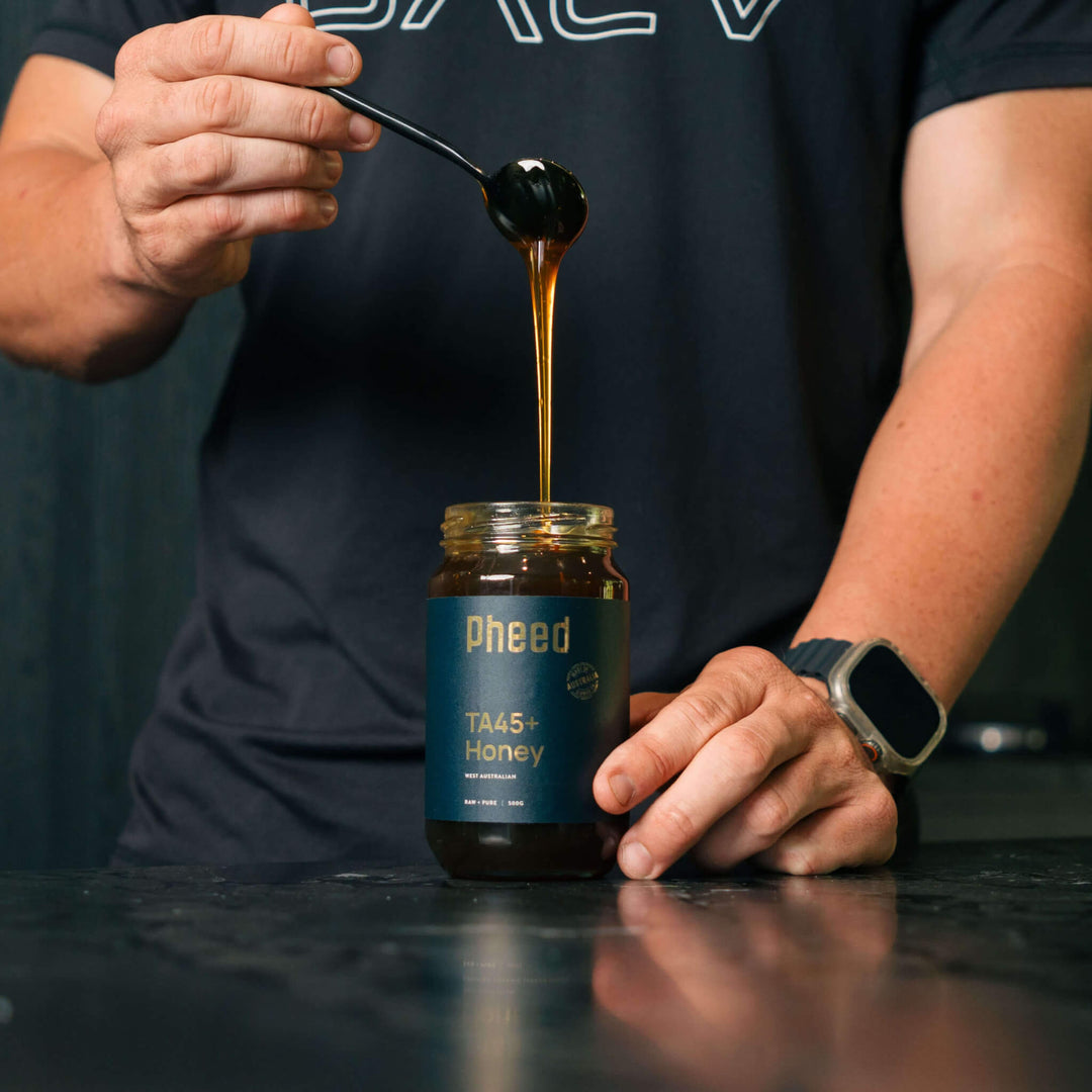 TA45+ Jarrah Honey drizzling from a spoon, highlighting thick and luscious texture.