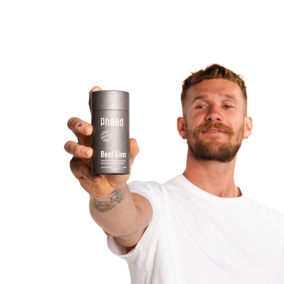 Man holding a 120-capsule bottle of Pheed Beef Liver Capsules against a white background.
