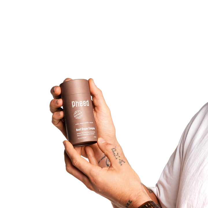 Close-up of Pheed Beef Organ Complex container held in two hands.