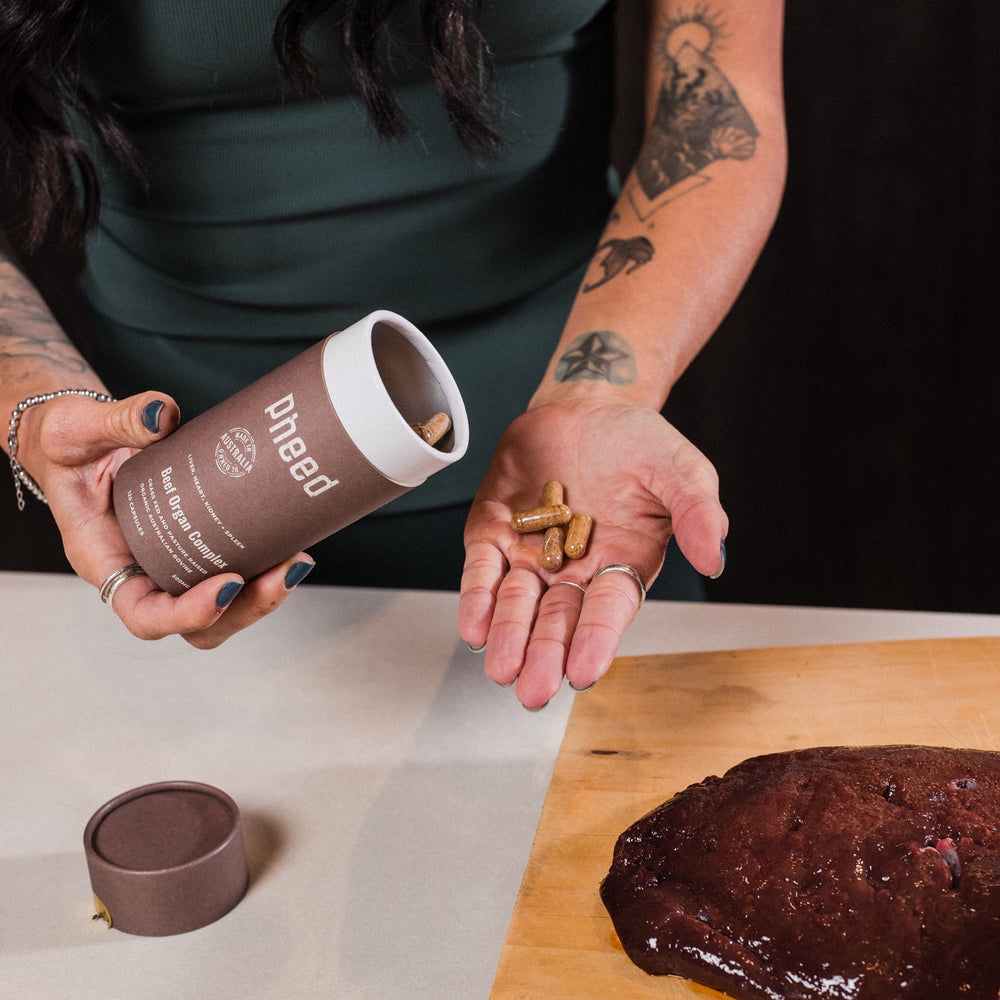 Pheed Beef Organ Complex capsules shown alongside fresh beef liver.