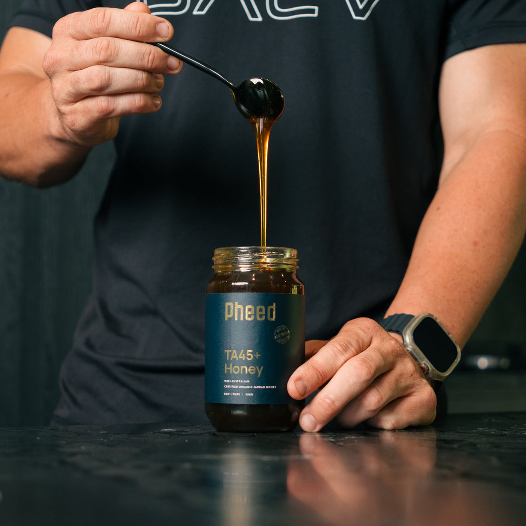 TA45+ Jarrah Honey from Western Australia with man holding a spoon with honey drip