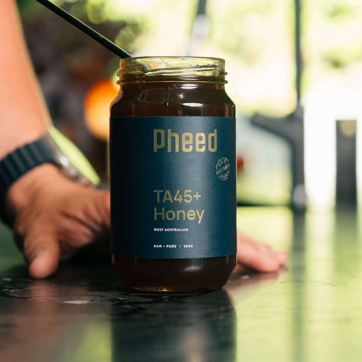 Raw organic honey jar placed in a natural kitchen setting.