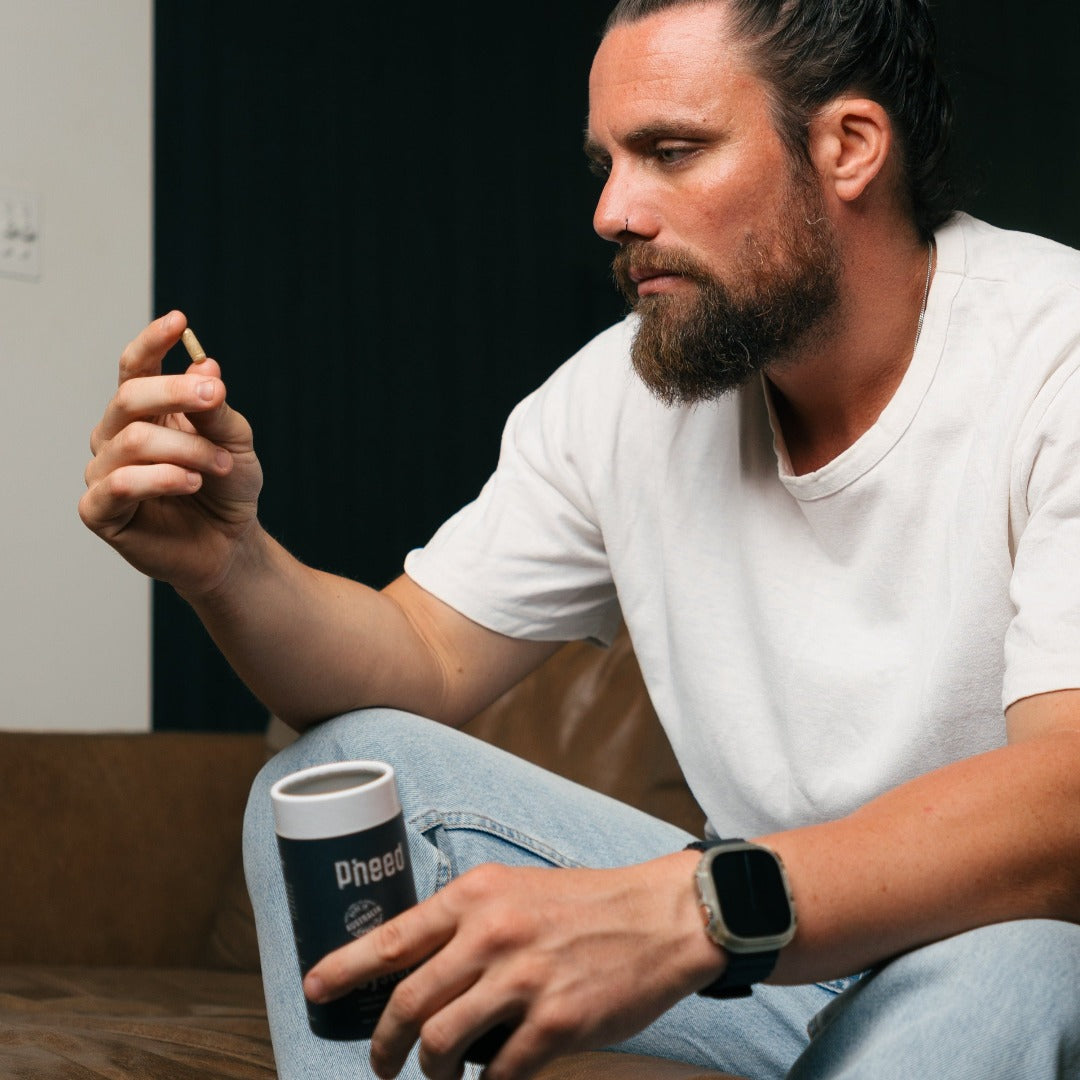 Man dressed in white shirt and blue jeans holding oyster capsule